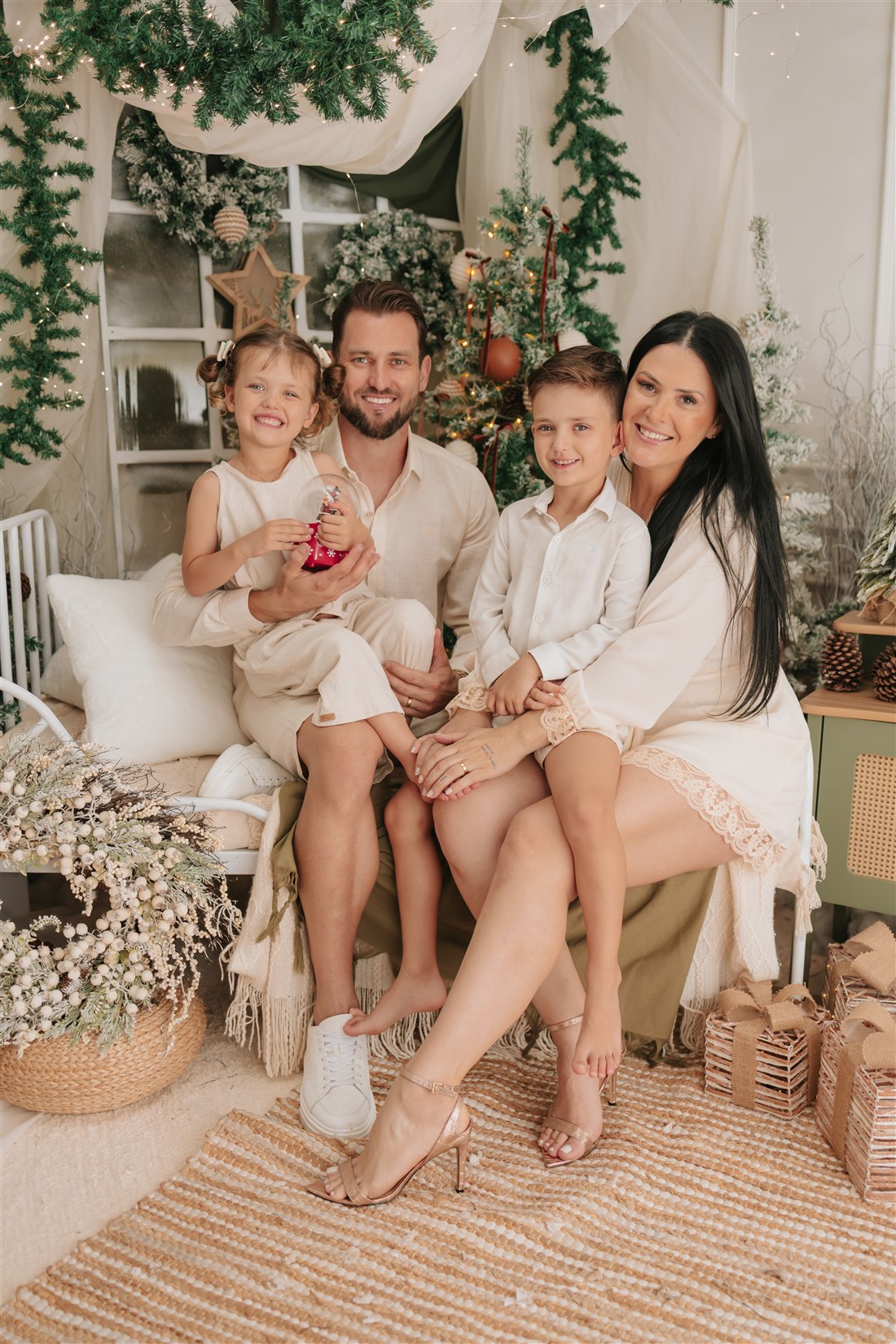 Família com duas crianças reunida no cenário de Natal
