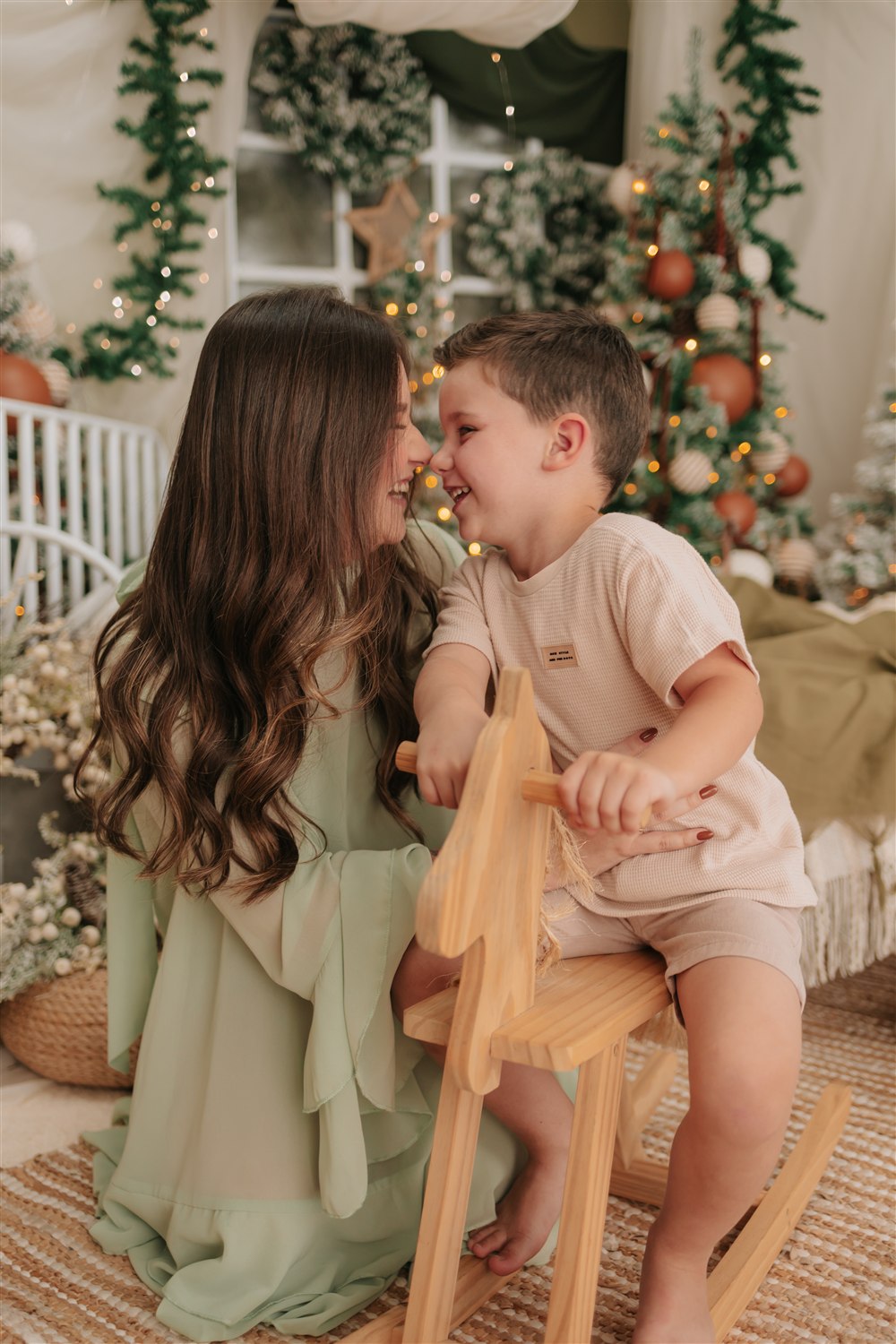 Dois irmãos sorrindo e brincando juntos no cenário de Natal